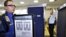 Transportation Security Administration screener Marlon Tejada, left, watches as Randy Parsons, TSA acting Federal Security Director, right, goes through a full body X-ray scanner for a security screening (File Photo)