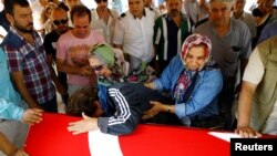 Relatives of Gulsen Bahadir, a victim of Tuesday's attack on Ataturk airport, mourn at her flag-draped coffin during her funeral ceremony in Istanbul, Turkey, June 29, 2016. 