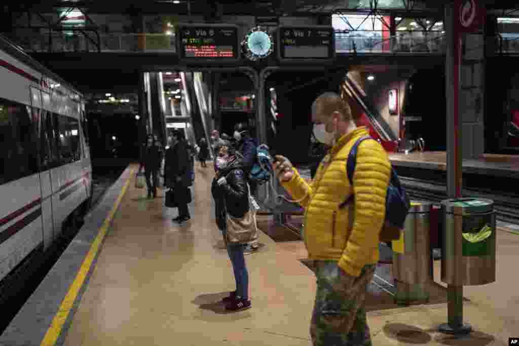 Usuarios del servicio de cercanías de la comunidad de Madrid esperan en la estación de Atocha para abordar su transporte, respetando las medidas de distanciamiento sugeridas y usando tapabocas para prevenir contagios.