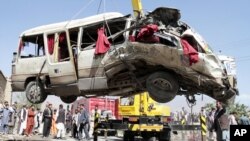 A damaged bus which was hit by a remote control bomb is lifted by a crane on the outskirts of Kabul, Afghanistan, August 7, 2012.