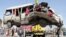 A damaged bus which was hit by a remote control bomb is lifted by a crane on the outskirts of Kabul, Afghanistan, August 7, 2012.