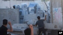 Warga Irak melempari batu saat bentrok dengan aparat keamanan di depan Kedutaan Besar Swedia di Baghdad, Irak, Kamis, 20 Juli 2023. Protes itu sebagai tanggapan atas pembakaran Alquran di Swedia. (Foto: AP)