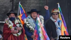 El presidente de Bolivia, Luis Arce (centro) saluda a la multitud en un acto en La Paz, flanqueado por su vicepresidente David Choquehuanca (izq.) y su antecesor Evo Morales (der.) el 25 de agosto de 2022. 