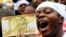 A protester displays a modified Kenyan 1,000 Shilling note ($12) imprinted with an image of a pig to depict what he says is greed in lawmakers demanding for a pay rise, during a demonstration in Nairobi, June 11, 2013.