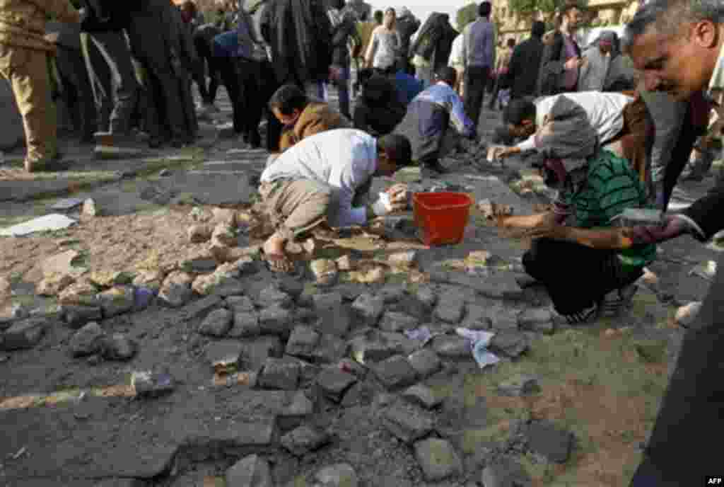 Anti-government protesters destroy the area around a monument in order to use the rubble for rocks during clashes in Tahrir, or Liberation square, in Cairo, Egypt, Wednesday, Feb. 2, 2011. Several thousand supporters of President Hosni Mubarak, including 