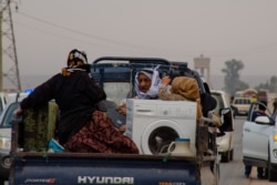 Families flee on the road from Ras al-Ayn the day before Kurdish-led forces pull out of the city, pictured in the outskirts of Ras al-Ayn, Syria, Oct. 19, 2019. (Yan Boechat/VOA)