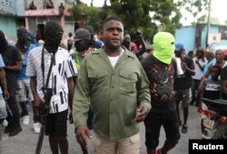 FILE—Former police officer Jimmy "Barbecue" Cherizier, leader of the 'G9' coalition, leads a march surrounded by his security against Haiti's Prime Minister Ariel Henry, in Port-au-Prince, Haiti September 19, 2023.