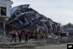 Buldoser membuka jalan al Rashid di Kota Gaza bagi warga Palestina yang kembali dari selatan ke utara Jalur Gaza, Sabtu, 25 Januari 2025, usai gencatan senjata Israel-Hamas berlaku. (Foto: AP)