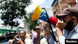 Un hombre sostiene un megáfono con la bandera de Venezuela durante un mitin político del líder opositor Carlos Ocariz, candidato a gobernador del estado Miranda, antes de las elecciones regionales de noviembre, en Caracas, Venezuela, el 19 de agosto de 2021.