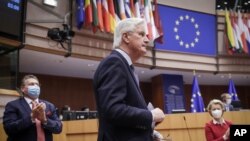 Head of the Task Force for Relations with the UK Michel Barnier, center, and European Commission President Ursula von der Leyen, right, attend a debate on the EU-UK trade and cooperation agreement at the European Parliament in Brussels, April 27, 2021.