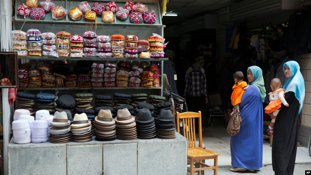 Perempuan etnis uighur mengenakan hijab di sebuah pasar di provinsi Xinjiang (foto: dok). Pemerintah Urumqi melarang perempuan mengenakan burka atau penutup wajah.