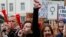 Polish women and some male supporters blow horns while raising a hanger, the symbol of illegal abortion, during a nationwide strike and demonstration to protest a legislative proposal for a total ban on abortion in Warsaw, Oct. 3, 2016. 