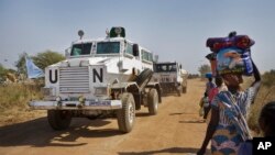 FILE - Displaced people are passed by a United Nations vehicle while walking towards a U.N. camp in Malakal, South Sudan, Dec. 30, 2013. Minister of Information says Dec. 15 was the expiration date for the deployment of peacekeepers to bolster the existing 12,000 U.N. troops in South Sudan. 