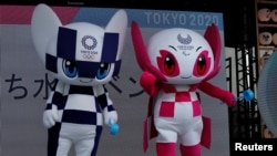 Tokyo 2020 Olympic Games mascot Miraitowa and Paralympic mascot Someity holds ladle to splash water during an old Japanese tradition called Uchimizu ritual, meant to cool down the air as the water evaporates, July 24, 2018. (REUTERS/Kim Kyung-Hoon)