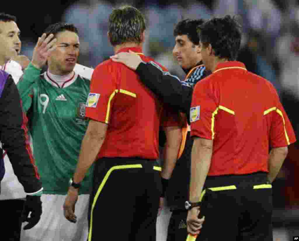 Mexico's Guillermo Franco, front left, argues with referee Roberto Rosetti of Italy, third from right, as Argentina's Diego Milito, second from right, looks on, following the World Cup round of 16 soccer match between Argentina and Mexico at Soccer City i