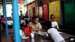 FILE - Expat children break for lunch at the American International School in Conakry, Guinea