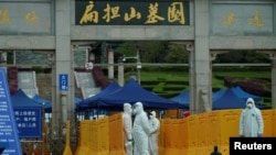 People wearing protective suits are seen in Biandanshan cemetery in Wuhan, Hubei province, the epicenter of China's coronavirus disease outbreak, April 1, 2020.