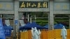 People wearing protective suits are seen in Biandanshan cemetery in Wuhan, Hubei province, the epicenter of China's coronavirus disease outbreak, April 1, 2020.