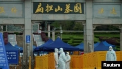 People wearing protective suits are seen in Biandanshan cemetery in Wuhan, Hubei province, the epicenter of China's coronavirus disease outbreak, April 1, 2020.