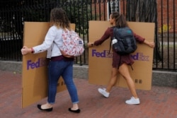 Students carry boxes to their dorms at Harvard University, after the school asked its students not to return to campus after Spring Break and said it would move to virtual instruction in Cambridge, Mass., March 10, 2020.