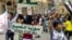 In this citizen journalism image, a protester holds up a Cross and Crescent painted with colors of the Syrian revolution flag during a demonstration against Syrian President Bashar Assad, May 18, 2012. 