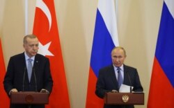 FILE - Turkish President Recep Tayyip Erdogan, left, and Russian President Vladimir Putin are seen during their joint news conference after talks at the Bocharov Ruchei residence in Sochi, Russia, Oct. 22, 2019.