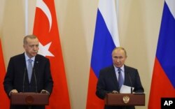 FILE - Turkish President Recep Tayyip Erdogan, left, and Russian President Vladimir Putin are seen during their joint news conference after talks at the Bocharov Ruchei residence in Sochi, Russia, Oct. 22, 2019.