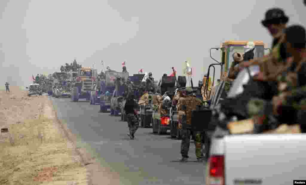 Shi&#39;ite paramilitary forces ride military vehicles traveling from Lake Tharthar toward Ramadi to fight against Islamic state militants, west of Samarra, Iraq May 27, 2015.