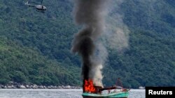 Perahu nelayan Vietnam yang tak berawak diledakkan dan tenggelam oleh angkatan laut Indonesia, di lepas pantai Natuna di Anambas, Kepulauan Riau, Indonesia, 5 Desember 2014. (Foto: dok).