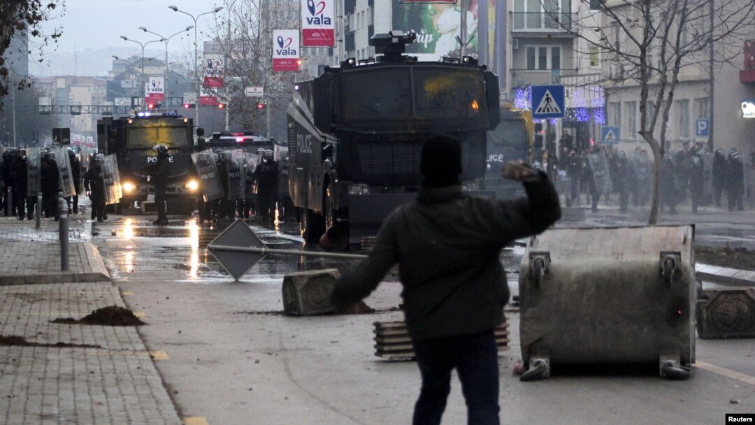 A protester throws a stone at police during clashes in Pristina, Kosovo, Jan. 9, 2016. Demonstrators in Kosovo fought running battles with police and briefly set fire to government headquarters on Saturday in the latest violence in the young Balkan country over an accord with its former ruler Serbia. 