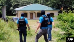 Honduran authorities at a seized property in Copan which belongs to the family of Digna Azucena Valle in Copan, who is imprisoned in the US on drug charges, August 18, 2014. 