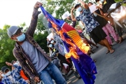 Protesters against Myanmar's junta burn the flag of the Association of Southeast Asian Nations, in Mandalay, Myanmar, June 5, 2021.