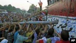 Protesters tear down a concrete wall built in front of the Israeli embassy in Cairo, Egypt, September 9, 2011