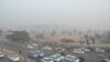 Delhi is blanketed in a grey haze of pollution on Christmas Eve as morning commuters pass by, Dec. 24, 2018.