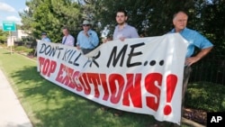 FILE - Protesters hold a sign against the death penalty outside the governor's mansion in Oklahoma City, June 18, 2013, protesting the execution of an inmate. 