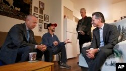 Gov. Gavin Newsom, right, visits veteran Vern Davis, second from left, during his tour of the Mather Veterans Village in Rancho Cordova, California, Dec. 5, 2019. 