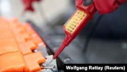 ILUSTRASI - Pemeriksaan tegangan aki mobil Lithium-ion bekas sebelum dibongkar oleh karyawan perusahaan daur ulang Jerman Accurec di Krefeld, Jerman, 16 November 2017. (Reuters/Wolfgang Rattay)