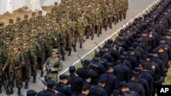 Fuerzas especiales del ejército y los oficiales de policía de El Salvador se relajan antes de ser presentados a los medios de comunicación como parte de una nueva fase intensificada en la lucha contra las pandillas. [Foto de archivo]