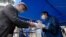 ဂျပန်နိုင်ငံ Yokohama မြို့မှာ ဘောလုံးကွင်းထဲမဝင်ခင် အဝင်ပေါက်မှာ အမျိုးသားတဦး လက်ထဲ ပိုးသတ်ဆေးရည် ထည့်ပေးနေတဲ့ အလုပ်သမားတဦး။ (အောက်တိုဘာ ၃၀၊ ၂၀၂၀)