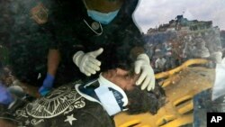 A U.S. doctor attends to Pemba Tamang inside an ambulance after being rescued by Nepalese policemen and U.S. rescue workers from a building that collapsed five days ago in Kathmandu, April 30, 2015.