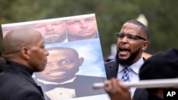 Dozens of Black Lives Matter and Black Panther protesters gather outside the Glynn County Courthouse where the trial of Travis McMichael, his father, Gregory McMichael, and William "Roddie" Bryan is held, Nov. 22, 2021, in Brunswick, Ga.