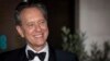 FILE - Richard E Grant poses for photographers upon arrival at the BAFTA Film Awards after party in London on Feb. 2, 2020.