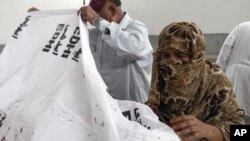 A Pakistani woman mourns the death of her brother who was shot dead by unknown gunmen, at a mortuary in Karachi, Pakistan, July 22, 2011.