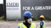 FILE - Construction workers stand in front of a 1Malaysia Development Berhad (1MDB) billboard at the Tun Razak Exchange development in Kuala Lumpur, Malaysia, February 3, 2016.