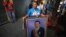 Una mujer sostiene una pintura del presidente Hugo Chávez: el tema de su juramentación también ha regresado a Venezuela.