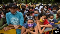 FILE - Venezuelan migrants wanting to return to their country due to the novel coronavirus COVID-19 pandemic, wait in Cali, Colombia, for a chance to get into a bus that will take them to the border, on May 12, 2020. 