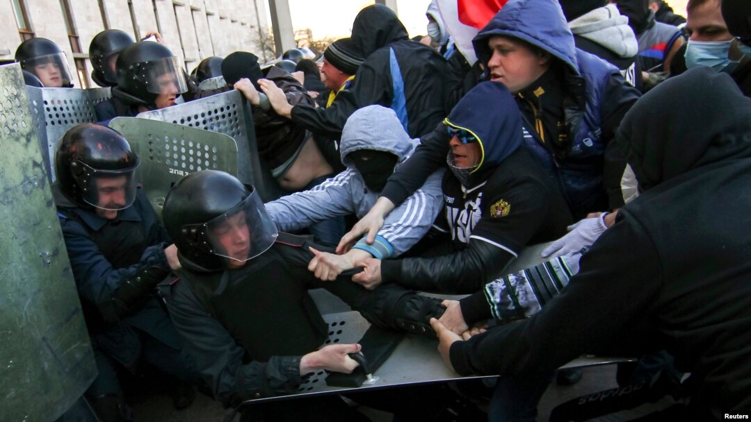 Pro-Russia protesters (R) scuffle with the police near the regional government building in Donetsk, April 6, 2014.
