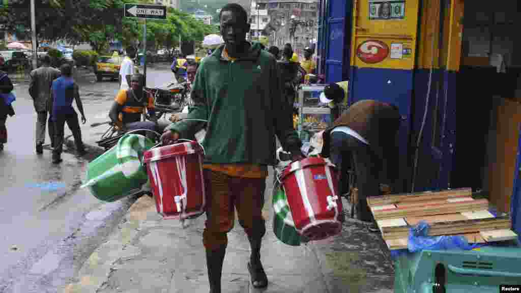 Un homme vent des seaux pour lavage des mains sur une rue de la ville de Monrovia, September 18, 2014. REUTERS/James Giahyue (LIBERIA - Tags: HEALTH SOCIETY DISASTER) - RTR46S4M 