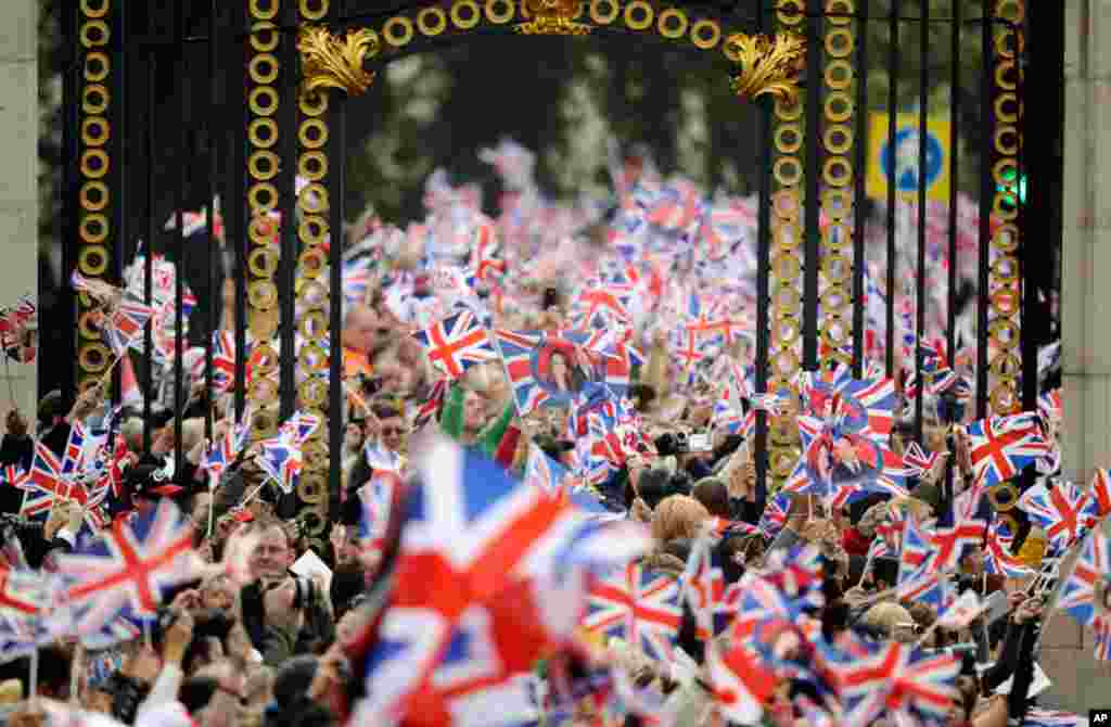 People wave British flags outside Buckingham Palace during the Royal Wedding, April 29, 2011 (Reuters/Dylan Martinez)
