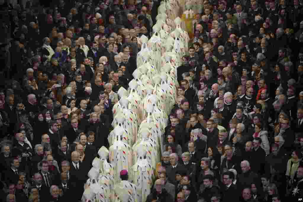 Guest watch clergy members leaving the inaugural mass at Notre Dame Cathedral, hosting its first Mass since the catastrophic fire of 2019, in Paris, France.